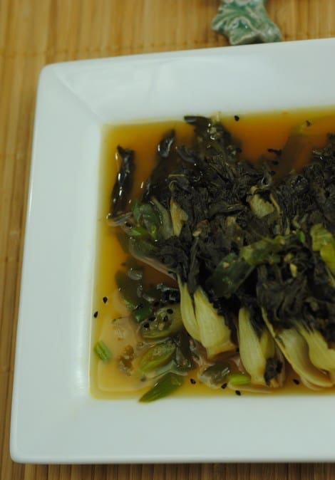 Low-amine baby choy sum sprinkled with nigella seeds, surrounded by spring onion broth. (photo)